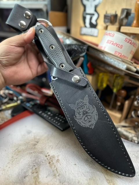 Custom, handmade dangler sheath with laser engraving for Busse Hallrazor 2. Features black leather with nickle hardware.